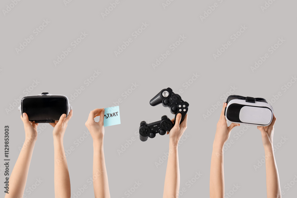 Female hands with game pads, VR glasses and word START on light background Female hands with game pads, VR glasses and word START on light background