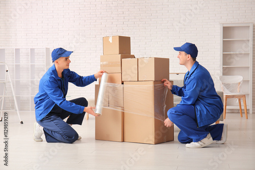 Male workers wrapping cardb...