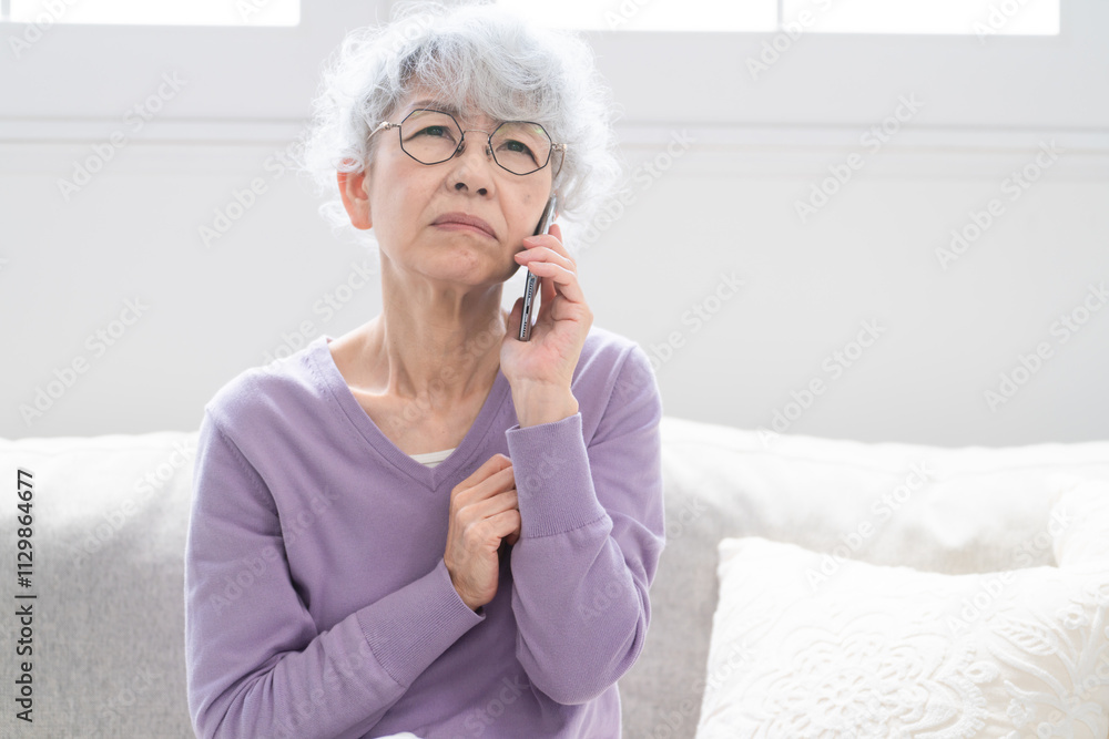 スマートフォンで通話をしているシニア女性	
