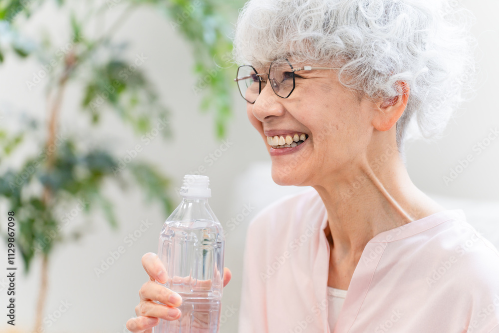 ペットボトルの水を飲むシニア女性 ペットボトルの水を飲むシニア女性