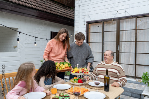 Multiracial family having fun and enjoying party outdoors in garden.  photo