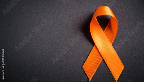 Leukemia Awareness Symbol. Orange Ribbon with Copy Space for Text. Dark Gray Background Isolated. Flat Lay Top View.