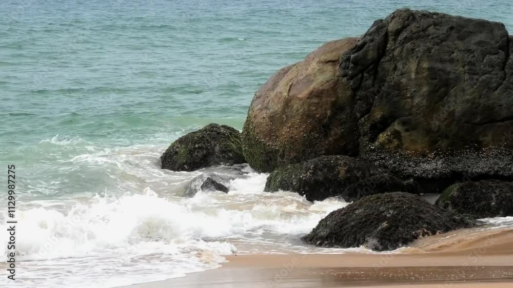 The foam of turbulent waves crashes on the rocks at Kovalam beach in Kerala, India The foam of turbulent waves crashes on the rocks at Kovalam beach in Kerala, India
