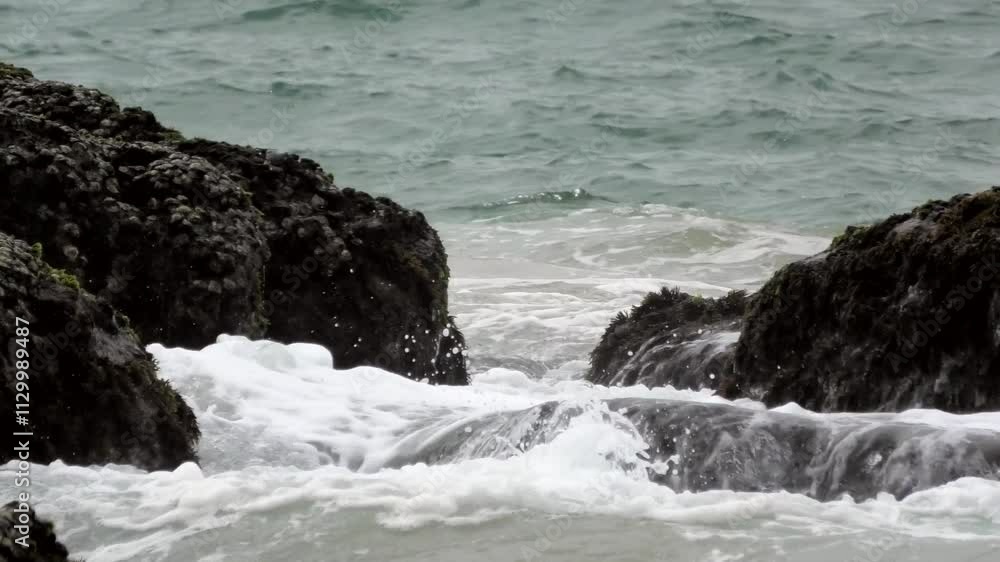 The foam of turbulent waves crashes on the rocks at Kovalam beach in Kerala, India The foam of turbulent waves crashes on the rocks at Kovalam beach in Kerala, India
