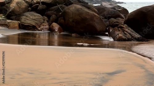 Kovalam beach in Kerala, India, with large rocks scattered across the sand