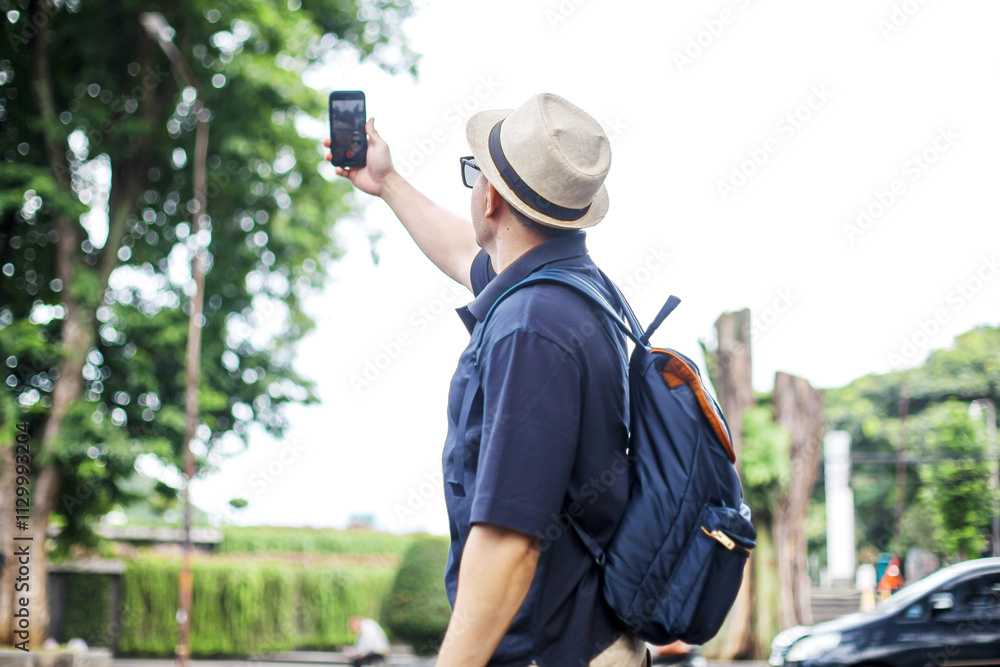 Obraz premium Portrait Of Traveler Man Doing Vlog Using Smartphone While Walking in City Street
