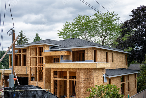 New modern house construction, wood framing with oriented strand board plywood sheeting on the exterior and asphalt shingle roof, real estate and mortgage background
 photo