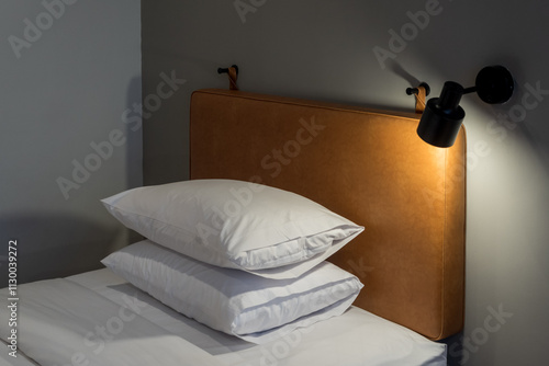 Close-up of a neatly made bed with soft lighting, offering comfort and modern elegance