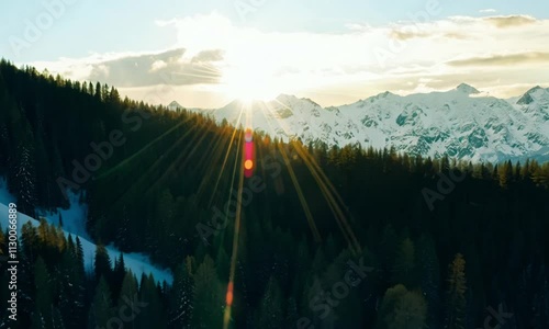 Morning Serenity on Snowy Peak, golden sunrise lights up the sky, filling the clouds with fiery colors photo