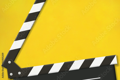 黄色い背景の開いたクラッパーボードが大きく写るフレーム