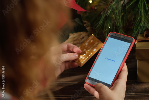 Paying online. Payment for Christmas shopping using smartphone and plastic bank card.