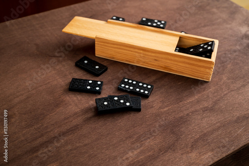 box of domino tiles on a wooden table