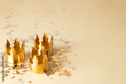 Three Golden crowns on beige star confetti background for Dia de Reyes Magos day ( Three Wise Men) or Epiphany day, 6 January