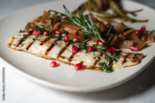 grilled juicy seabass served with butter garlic sauce, mediterranean herbs, sevketi bostan called holy thistle and pomegranate seeds