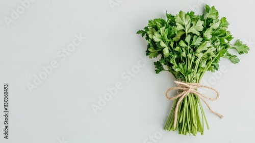 A bundle of dried parsley tied neatly with raffia string, isolated on a simple white surface photo