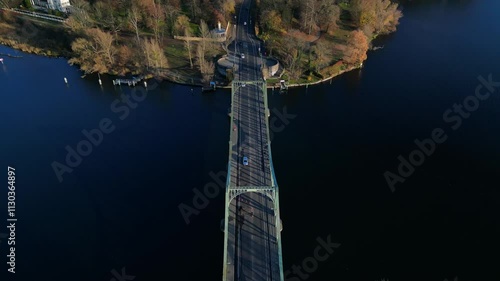 Cars crossing Glienicker Bridge over Havel river in autumn. Smooth aerial view flight drone shot footage from above photo