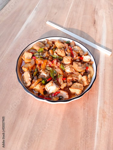 stir-fried knuckle or trotter with tofu served with plate on wooden background. chewy and soft dish. asian cuisine. oseng tahu kikil photo