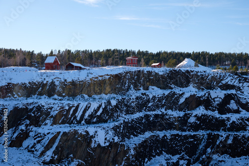 Winter landscape of the historic Falun Mine in Dalarna, Sweden, under a clear blue sky