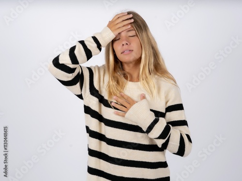 Beautiful teen girl wearing striped sweater Touching forehead for illness and fever, flu and cold, virus sick. photo