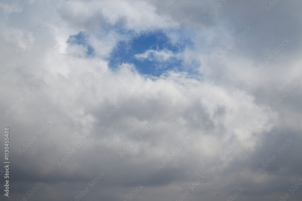 Obraz premium A window in a cumulus cloud through which the blue sky is visible, a gap in the cloud