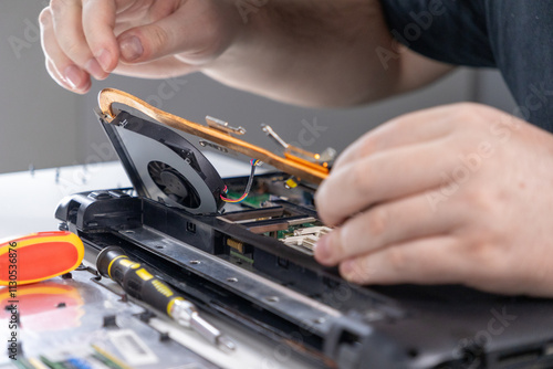 Wallpaper Mural removing a laptop cooling system for cleaning during maintenance, close-up of a technician carefully disassembling internal components Torontodigital.ca