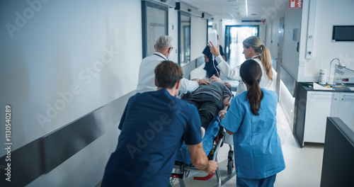 Photography Diverse Emergency Medical Team Rushing Down a Hospital Corridor, Carefully Pushing a Stretcher with an Injured Patient