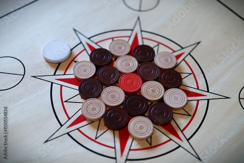 Carrom Pieces Arranged on a Wooden Star Pattern Board photo