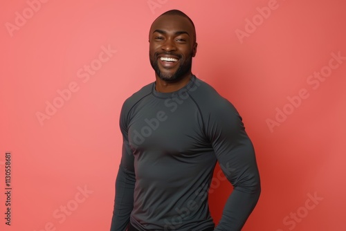 Portrait of a glad man in his 30s showing off a lightweight base layer in solid color backdrop photo