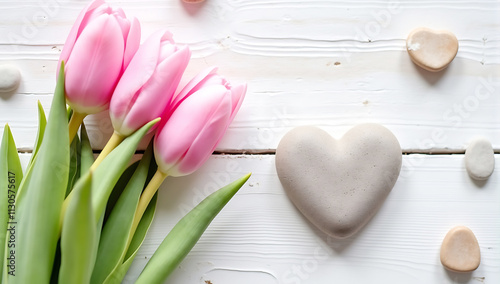 Beautiful tulips with stone heart on light wooden background, romantic composition, spring flowers, pastel colors, Valentine's Day theme