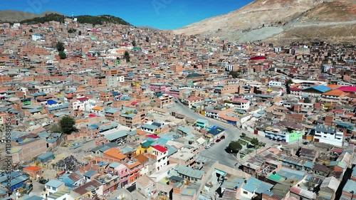 Drone shot of a vibrant neighbourhood in Potosi, Bolivia, showcasing winding roads on the hills. The aerial view captures the colourful homes, scenic terrain, and rich landscape of the region photo