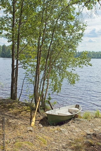 Row boat on lake shore at Moksi in summer, Finland. photo