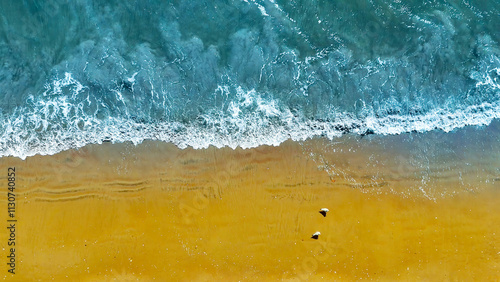 Aerial View of Waves on Sandy Beach. Top-down view of ocean waves gently meeting a golden sandy beach, showcasing natural textures and vibrant coastal colors.