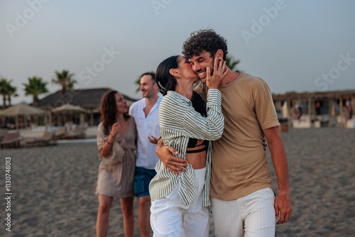 Photos Girl kissing her boyfriend on the cheek on a sandy beach