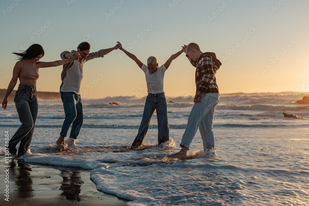 Fototapeta premium Friends holding hands and enjoying sunset on beach