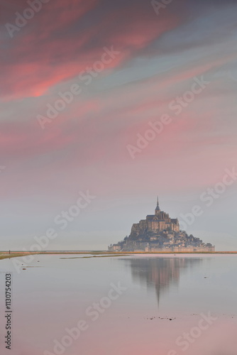 Mont-Saint-Michel coloful dawn, tidal island in the homonymous bay reflected at high tide in the mirroring floodplain around it. Normandy-France-085 photo