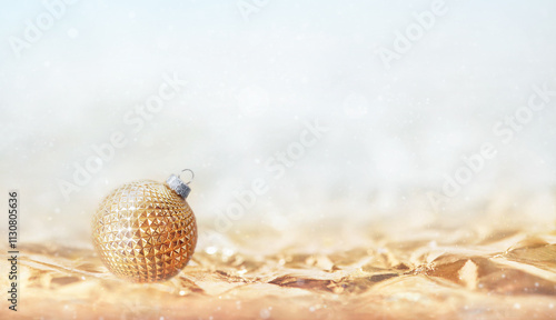 One golden Christmas ball with geometric pattern on soft bokeh background. copy space