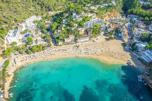 Aerial view of Cala Vadella, Ibiza, showcasing turquoise waters, sailboats, sandy beaches, and luxury villas photo