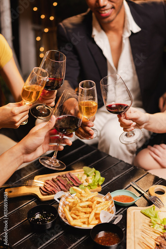 Sticker Group of friends clinking wine glasses in celebration at night, Festival celebration, Happy Asian group friends and dinner party in the night, Friendship and celebration new year concept