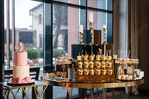 Delicious reception. Birthday Cake on a background candy bar. Celebration concept. Table with sweets, candies, dessert. Trendy cake is decorated with a bear figure for baby girl for 1, 2, 3 years.