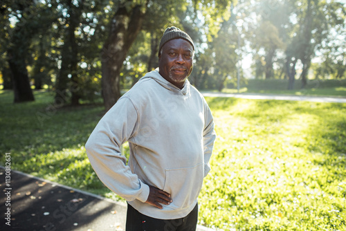 Portrait of a senior man jogging in sunny park trail photo