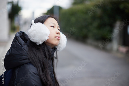 冬の朝の住宅地の道路にいる塾に行く小学生の女の子の姿 photo