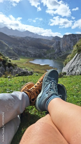 couple of people showing their feet in front of the lake and the mountains