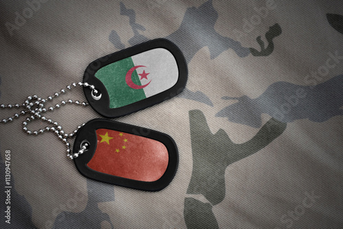 vintage army blank, dog tag with flag of algeria and china on the khaki texture background. military concept. photo