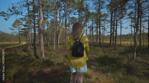 Woman walking on the swamp lake. Bog hiking.