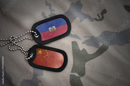 vintage army blank, dog tag with flag of haiti and china on the khaki texture background. military concept. photo