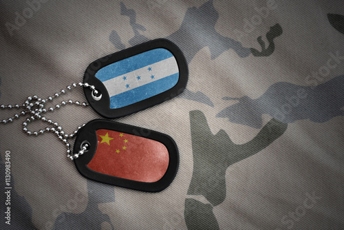 vintage army blank, dog tag with flag of honduras and china on the khaki texture background. military concept. photo