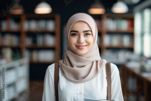 Muslim woman with her head covered stands in the library among books. Islamic education concept for women photo