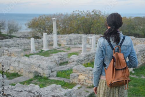 Obraz na płótnie A young tourist stands against the backdrop of the ruins of ancient Chersonesus in Sevastopol in Crimea. Travel concept. w salonie