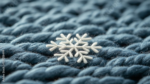 Snowflake on blue knit fabric, symbolizing winter charm. photo