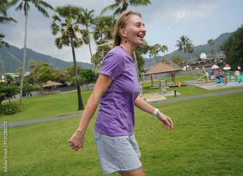A woman is rollerblading gracefully on a road located in a park